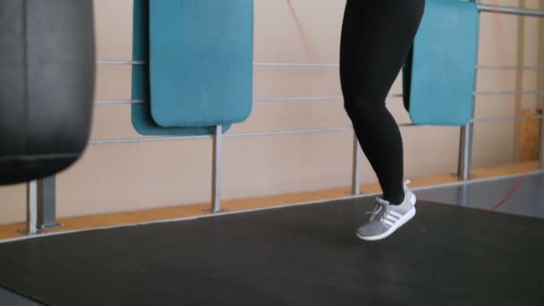 Joven boxeadora con las manos envueltas en vendaje saltando sobre la cuerda en un gimnasio . — Vídeos de Stock