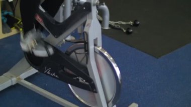 Bir bisiklet ve yakıcı kalori ile spor salonunda egzersiz genç sportif kadın. Fitness ve kardiyo eğitim kavramı