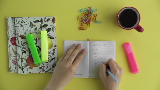 Ovanifrån av kvinna som skriver sin plan i dagbok. Fitness, arbete, frukost och engelskalektioner — Stockvideo