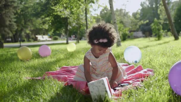 Feliz niña africana dibujando en el parque con globos multicolores sobre fondos — Vídeos de Stock