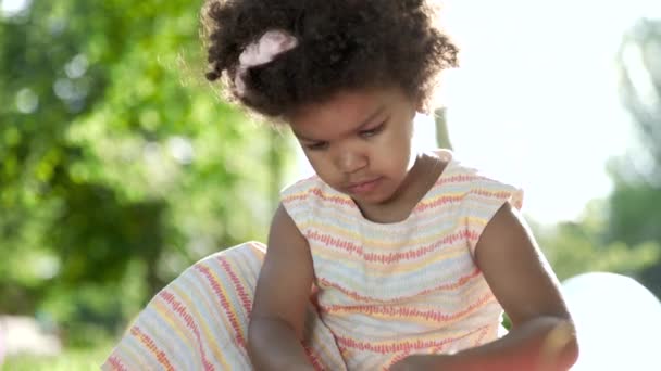Kleine afrikanisch-amerikanische Mädchen spielen Marker im Park — Stockvideo