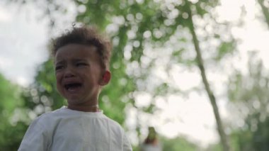 Küçük Afro-Amerikan çocuk parkta ağlıyor..
