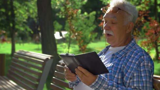 Side view of Elderly man with mustache understood how to open the application in tablet computer. He talk with himself — Stock Video