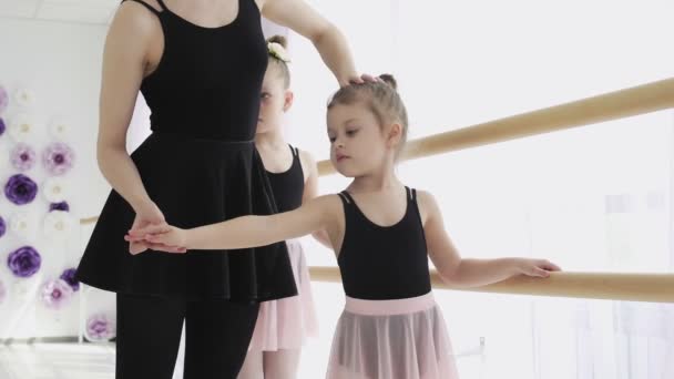 Uma mulher e uma rapariga numa escola de ballet. Adulto bailarina praticando com as meninas e trens russo balé clássico — Vídeo de Stock