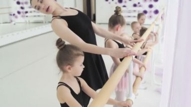 Bale okulundaki kız dansçı dans etmeyi öğreniyor. Tutular içinde zarif kızlar stüdyodaki panoramik pencerenin önünde bale yapıyorlar..