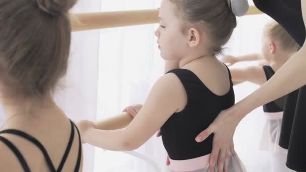 Dançarina na escola de balé aprende a dançar. Pequena bailarina em treinamento em terno de dança preta . — Vídeo de Stock