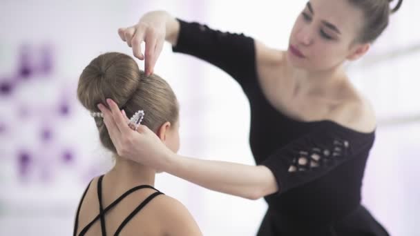 Joven profesora de danza arreglando el peinado a su estudiante — Vídeos de Stock