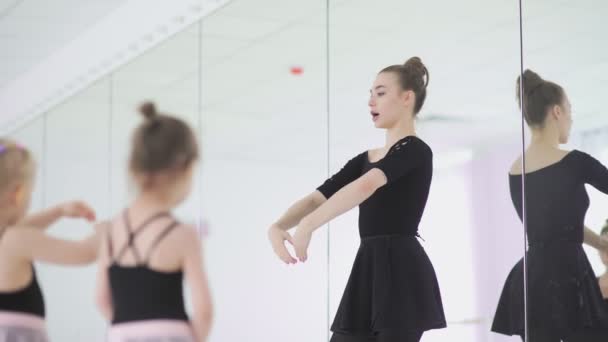 Мила вчителька балету дає урок маленьким дівчаткам — стокове відео