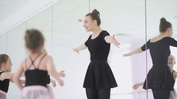 Linda profesora de ballet y sus pequeños estudiantes se están abrazando — Vídeo de stock