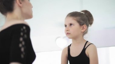 Şirin bayan bale öğretmeni üzgün öğrencisine sakinleşmesi için bir oyuncak veriyor.