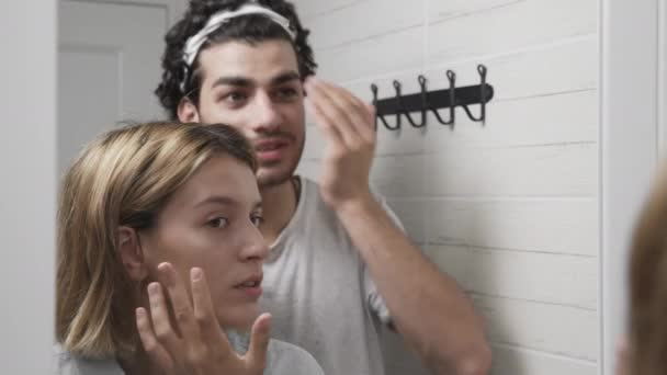 Jeune couple homme et femme touchant leurs visages dans la salle de bain — Video