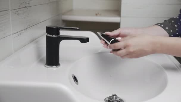 Kvinnan klämmer svart gel skrubb eller svart mask i hennes öppna handflata när hon står i badrummet — Stockvideo
