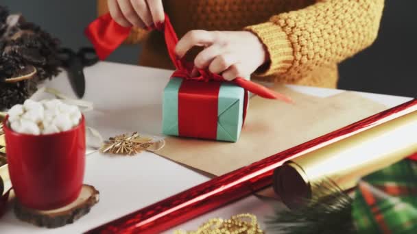 Onherkenbare vrouw die kerstcadeautjes uitpakt op tafel met kerstversiering. — Stockvideo