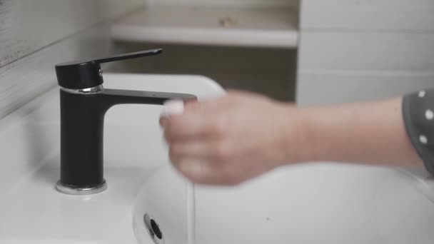 Vrouw wassen haar handen door water van kraan — Stockvideo