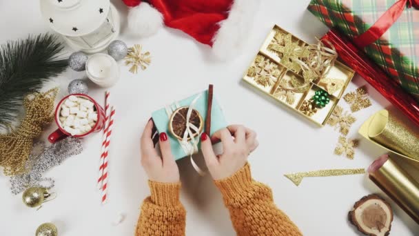 Noel hediyesini paketleyen ve dekore eden kadın kuru portakal ve küçük noel balosundan. — Stok video