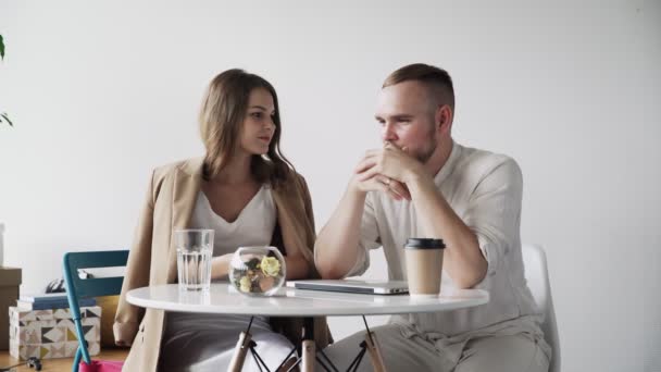 Triste homme parlant avec une belle collègue féminine. Une jeune équipe de bureau travaillant ensemble sur un projet commercial ou financier — Video