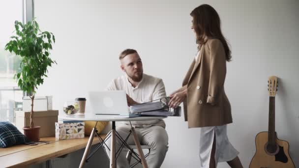 Gerente trajo al trabajador masculino una gran cantidad de carpetas con documentos — Vídeos de Stock