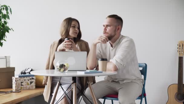 Mann und Frau sitzen in der Pause im Café am Tisch und unterhalten sich. — Stockvideo