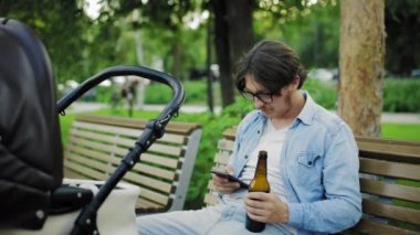 Babam telefon eder ve bebek arabasının yanında bira içer.