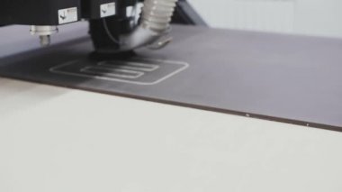 Bir endüstriyel testere ve vakum makinesi bir fabrikada plastikten parçalar kesiyor..