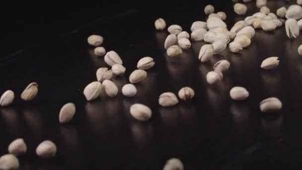 Pistachios are Rolling down on a black surface — Stock Video