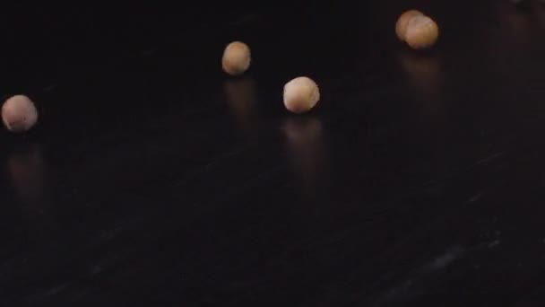 Noisettes roulent vers le bas sur une surface noire 