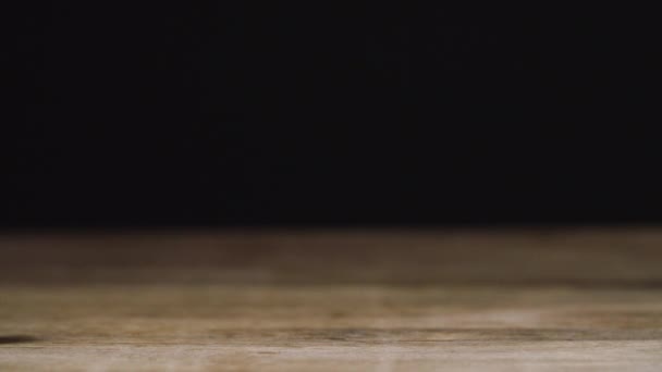 Haselnüsse fallen auf eine Holzoberfläche mit schwarzem Hintergrund — Stockvideo