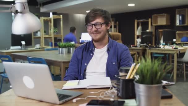 Mladý muž se dívá na legrační video v kanceláři — Stock video