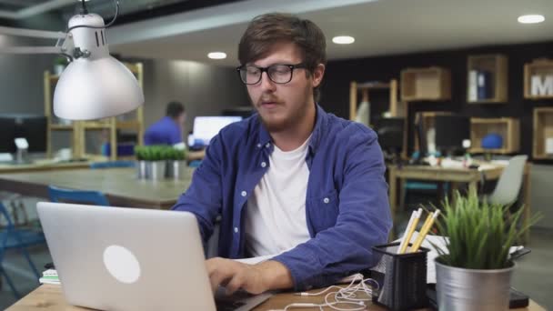 Jeune homme d'affaires travaillant sur ordinateur portable dans le bureau — Video