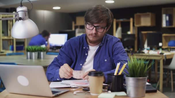 Joven escribe notas en pegatinas multicolores pegajosas usando pluma — Vídeo de stock