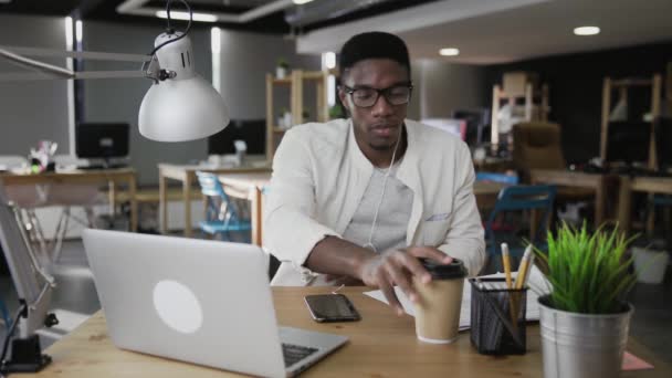 Africký podnikatel používá notebook a pije kávu — Stock video