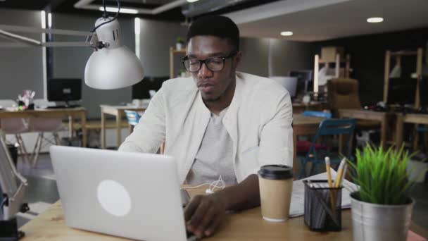 El hombre de negocios africano cansado está cerrando el cuaderno y se inclina hacia atrás — Vídeo de stock