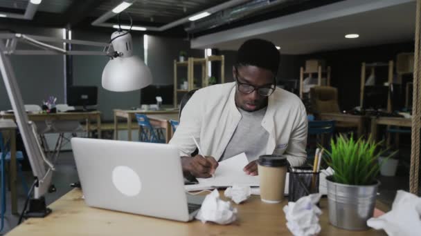 Moe Afro-Amerikaanse zakenman werkt aan bureau gooien van papier — Stockvideo