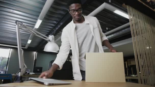 L'uomo africano assunto di recente in azienda entra in un nuovo ufficio. Maschio unbox suoi effetti personali — Video Stock