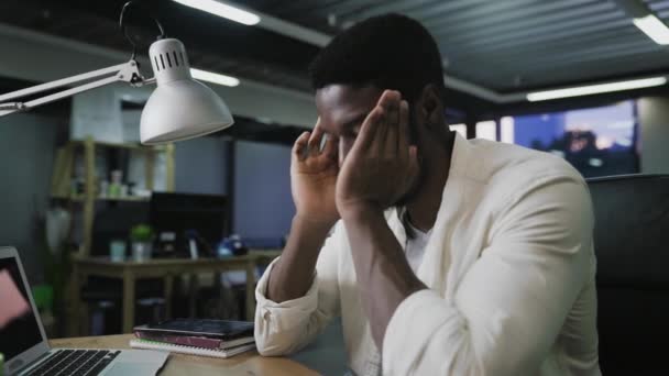 Nahaufnahme eines gestressten Afroamerikaners mit Kopfschmerzen bei der Arbeit am Laptop, Kamera schiebbar