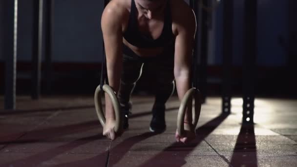 Muskulös kvinna gör armhävningar på gymnastik ringar — Stockvideo