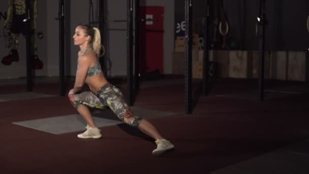 Ισχυρή και τακτοποίηση όμορφη αθλητική γυναίκα κάνει ασκήσεις τεντώματος — Αρχείο Βίντεο