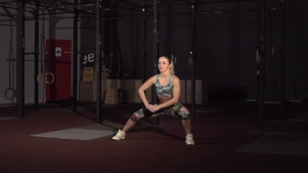 Fitness kvinna stretching sina muskler innan träning på crossfit gym. — Stockvideo
