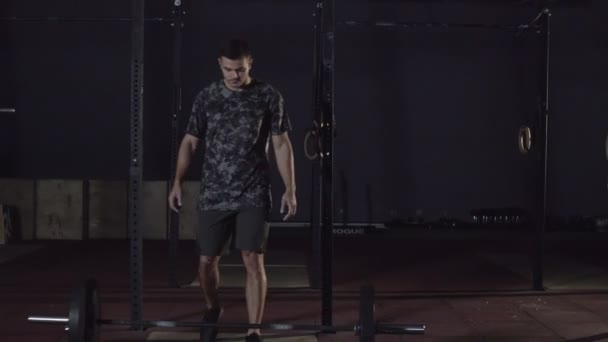 Hombre realizando ejercicio de levantamiento de pesas con barra de peso. Confiado joven haciendo levantamiento de pesas barra de entrenamiento en el gimnasio crossfit . — Vídeos de Stock