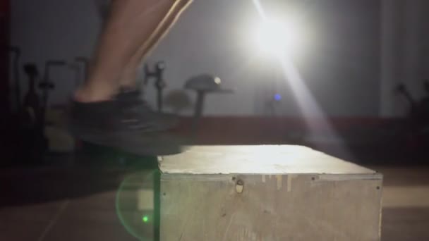 Hombre atlético hace conjunto de saltos de caja en un gimnasio crossfit — Vídeo de stock