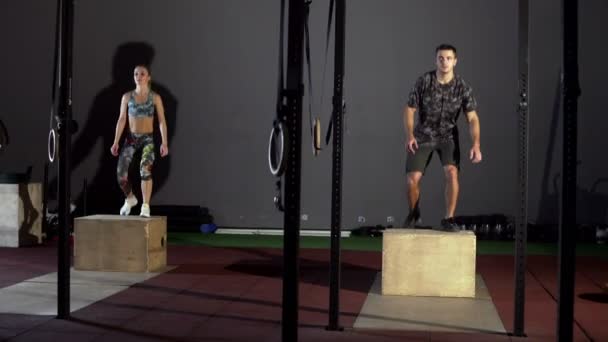 Homme athlétique fait ensemble de sauts de boîte à une salle de gym Crossfit — Video