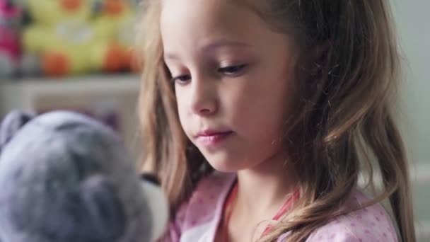 Portrait of expressive little girl hugging her plush bear friend — Stock Video