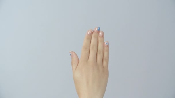 Jovem mulher olha para sua manicure profissional brilhante fresco . — Vídeo de Stock