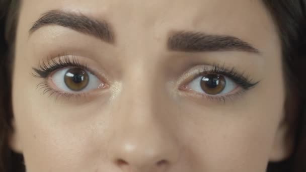 Kvinnan blinkar med sina bruna ögon och leker ögonbryn — Stockvideo