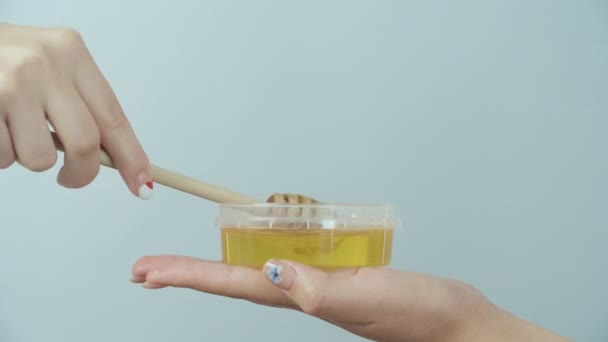 Honung droppande från honung skopa på blå bakgrund — Stockvideo