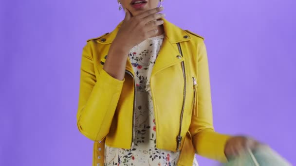Στοχαστική επιτυχημένη αφροαμερικανή γυναίκα με χρήματα ανεμιστήρα σε μωβ φόντο στο στούντιο. Κίτρινο σακάκι — Αρχείο Βίντεο