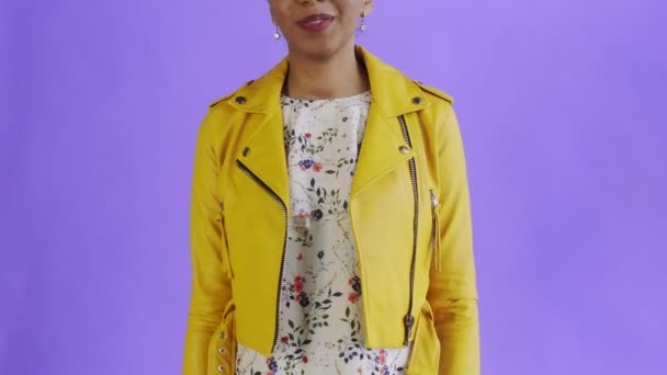 Satisfait heureux excité femme afro-américaine montrant de l'argent et disant oui sur fond violet Veste jaune — Video