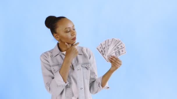 Nachdenklich erfolgreiche afrikanisch-amerikanische Frau mit Geld auf blauem Hintergrund Jeansjacke — Stockvideo