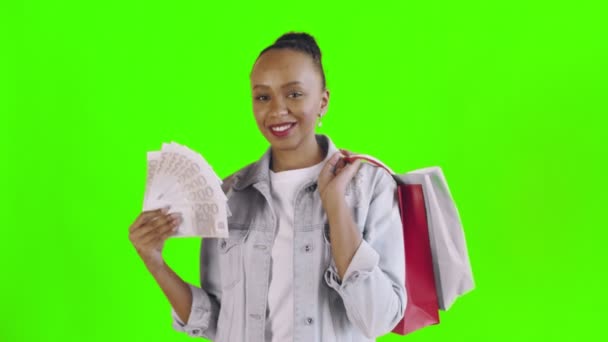 Retrato de mujer afroamericana con bolsas de compras y abanico de dinero sobre fondo verde en Studio. Chaqueta Jean — Vídeo de stock