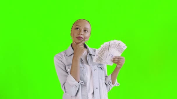 Thoughtful successful african american woman with money on green background Jean jacket — Stock Video